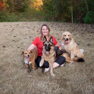 woman posing with her three dogs